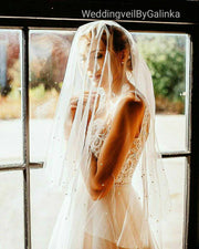 Wedding veil with a scattering of pearls around the edge.