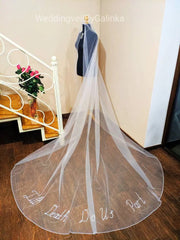 Wedding veil with phrases, words, letters embroidered with beads.