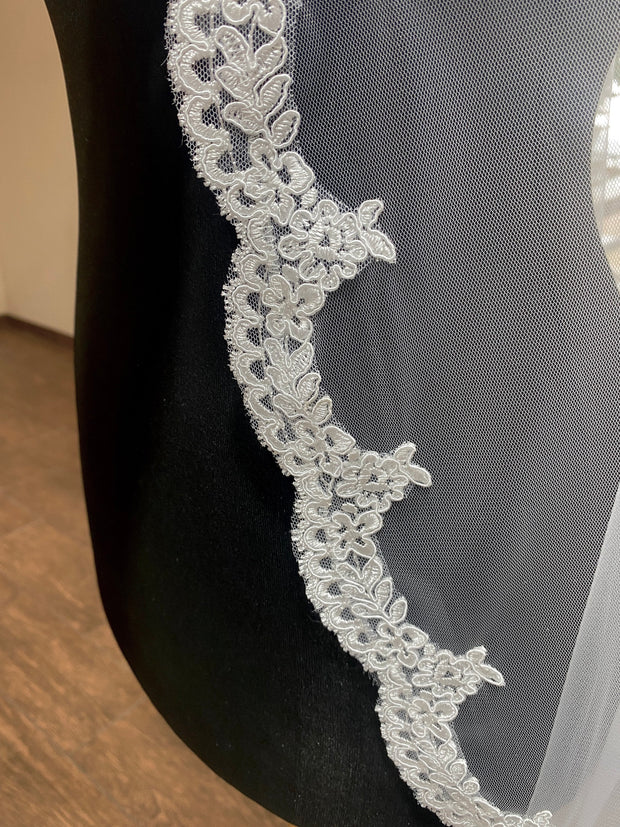 Lace wedding veil for the bride fixed on a comb