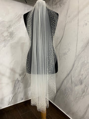 Wedding veil with pearls. A scattering of pearls along the edge of the veil.